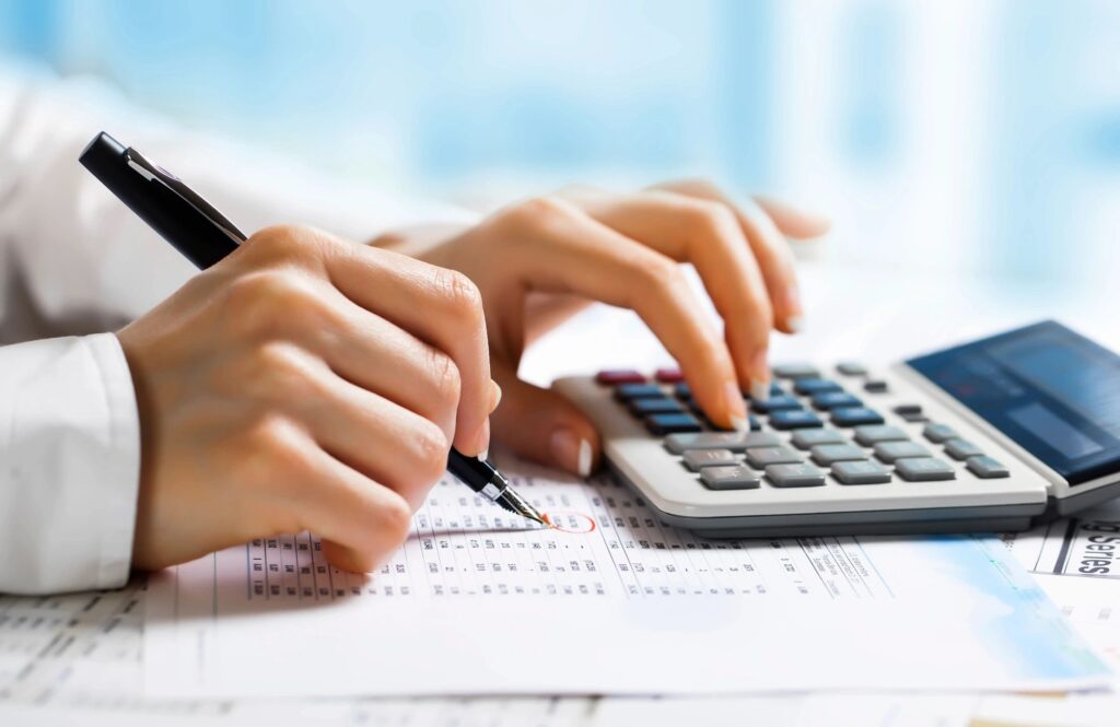 Person Calculating with Financial Reports - Personal Finance Tools