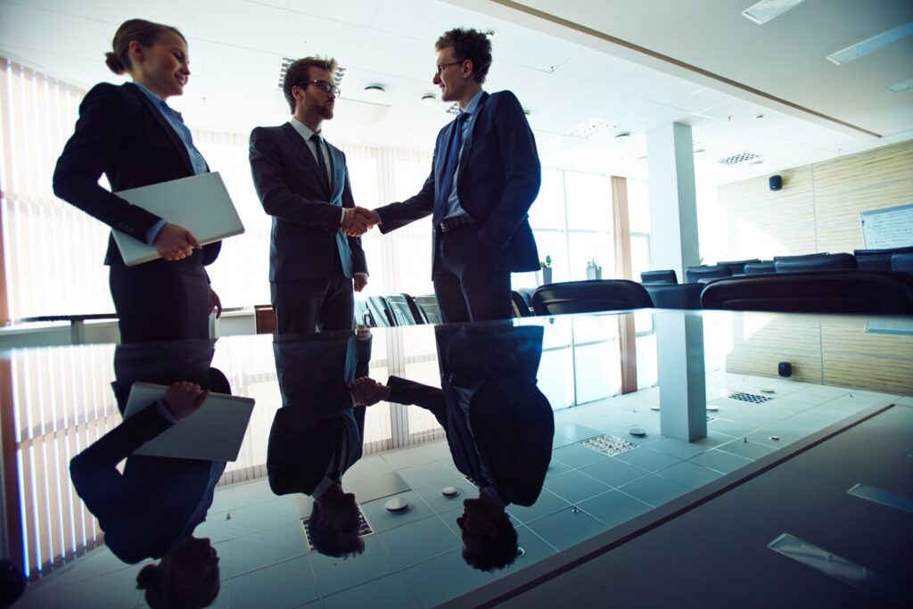 Two professionals shaking hands, symbolizing a limited partnership for investment collaboration.